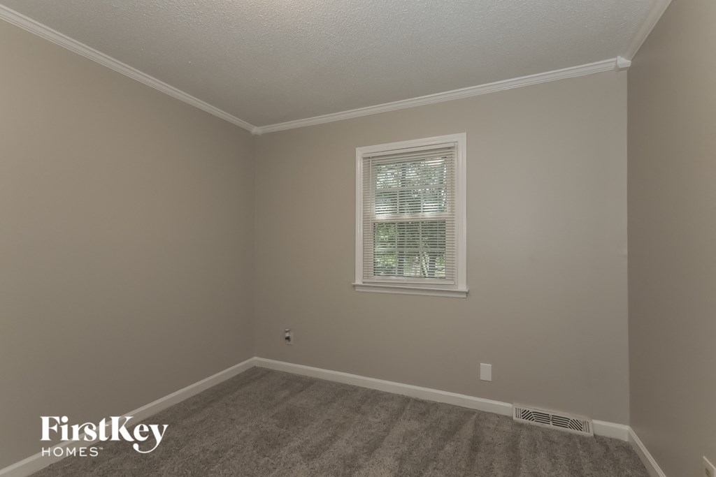 a empty room with a window and a carpet
