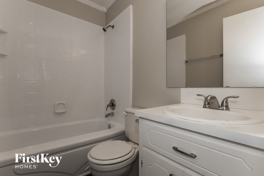 a white bathroom with a sink toilet and tub