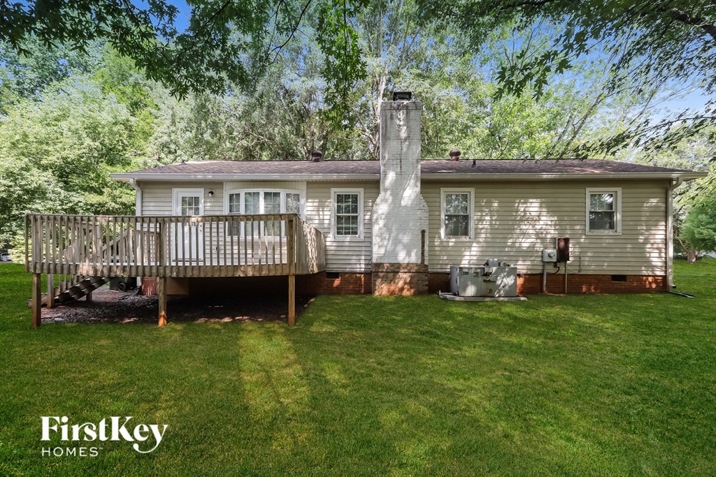 a small white house with a deck and a yard