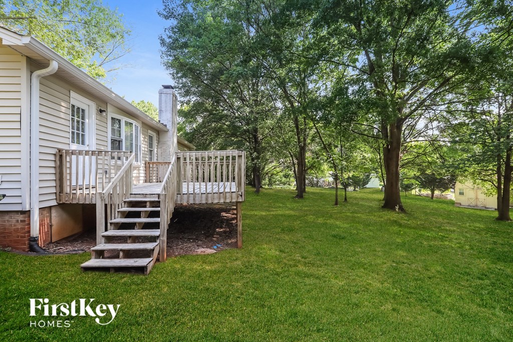 A house with a deck and stairs in the backyard.