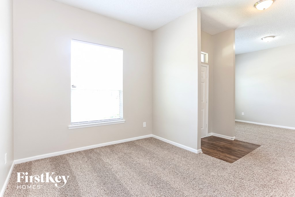 a room with carpet and a window and a door