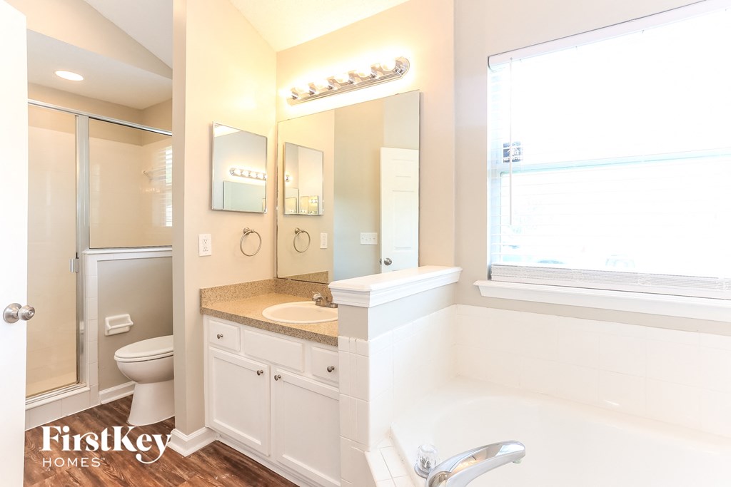 a bathroom with a tub and a sink and a toilet