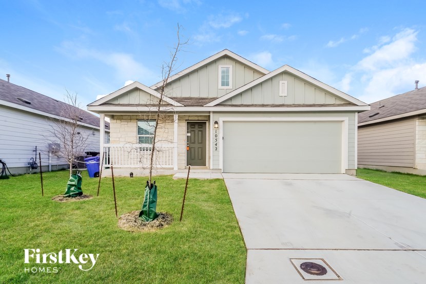 A house with a garage and a driveway in front of it.