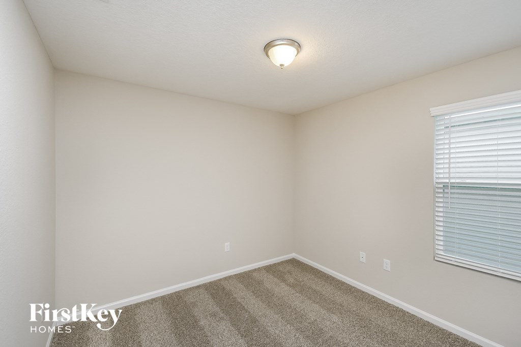 the upstairs bedroom has carpet and a large window