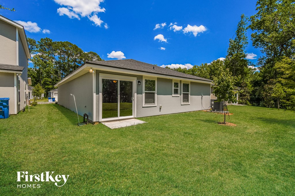 a gray house with a grassy yard and trees
