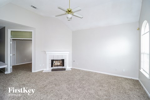 a living room with a fireplace and a ceiling fan