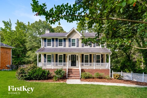 A house with a porch and a white picket fence.
