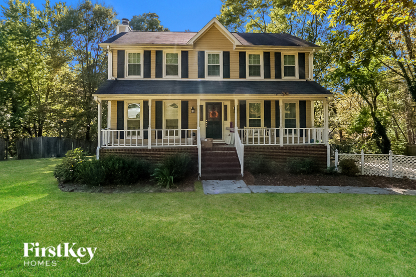 A house with a porch and a white picket fence.