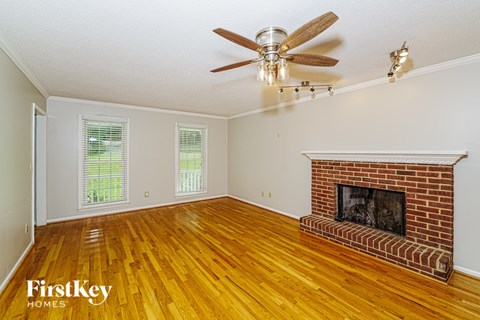 A room with a fireplace and a ceiling fan.
