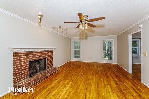 A room with a fireplace and wood floors.