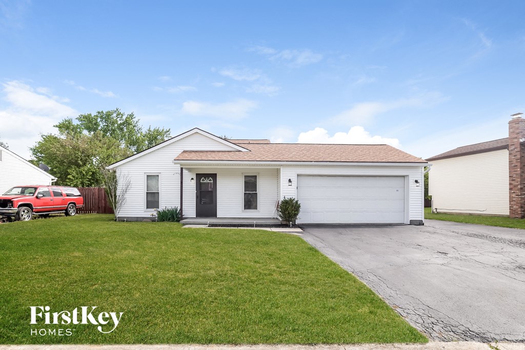 a white house with a driveway and a lawn