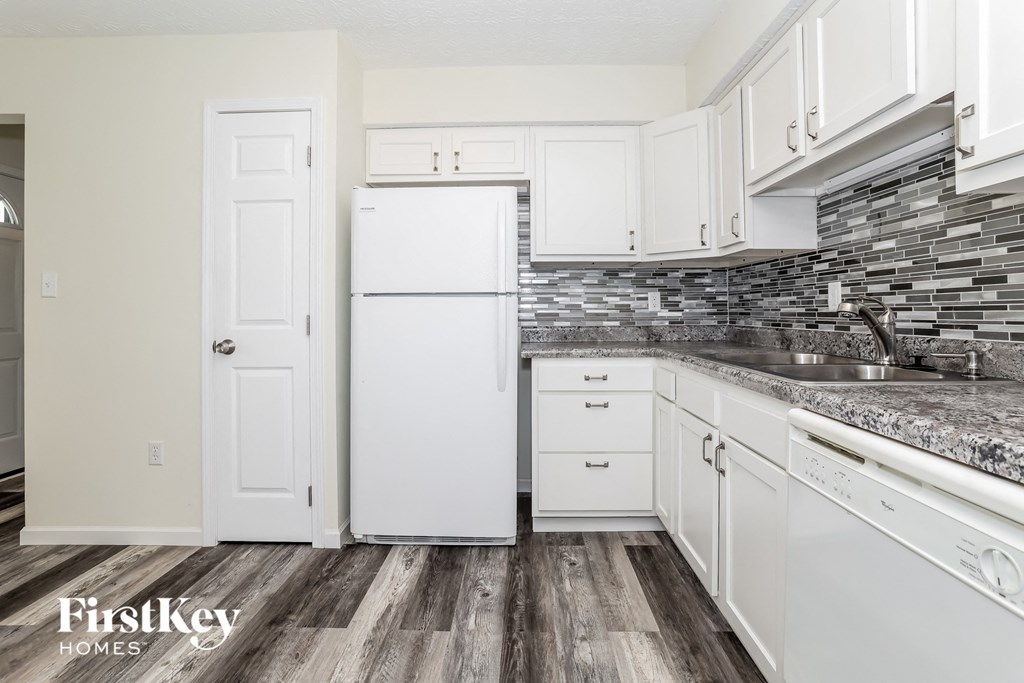 a kitchen with white cabinets and a white refrigerator