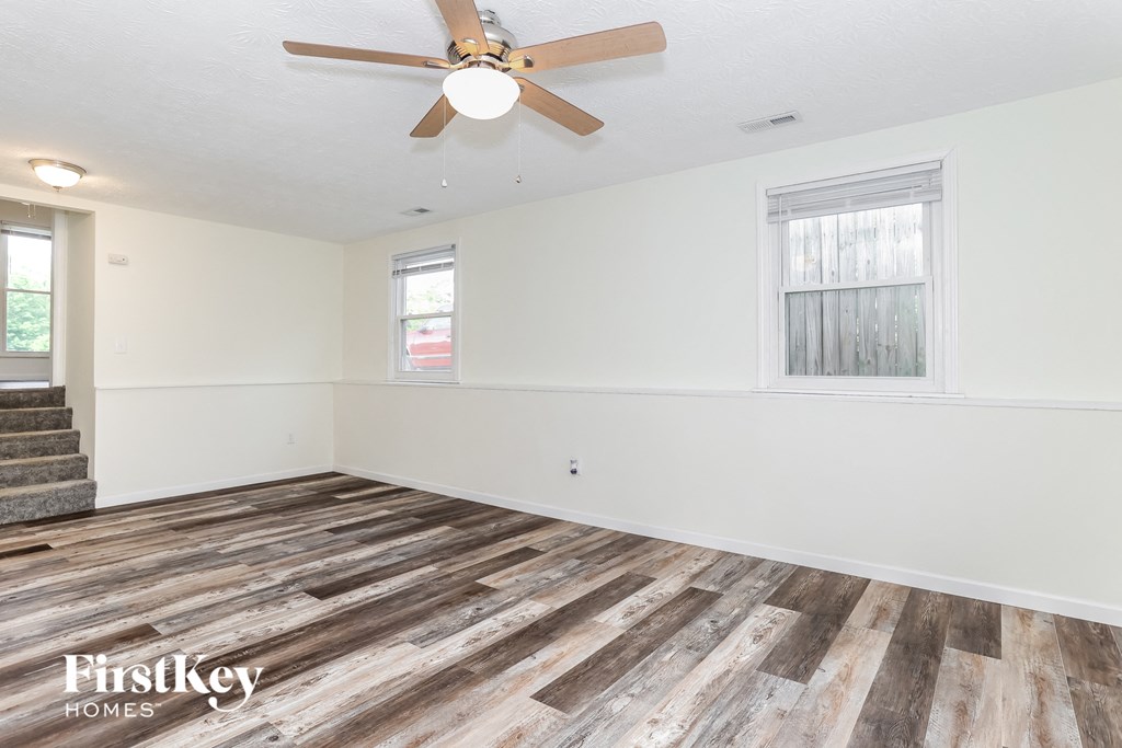 a living room with wood floors and a ceiling fan