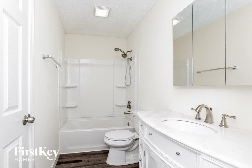 a white bathroom with a shower and a sink and a toilet