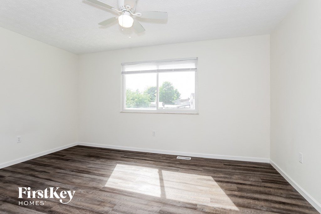 a living room with a window and a ceiling fan