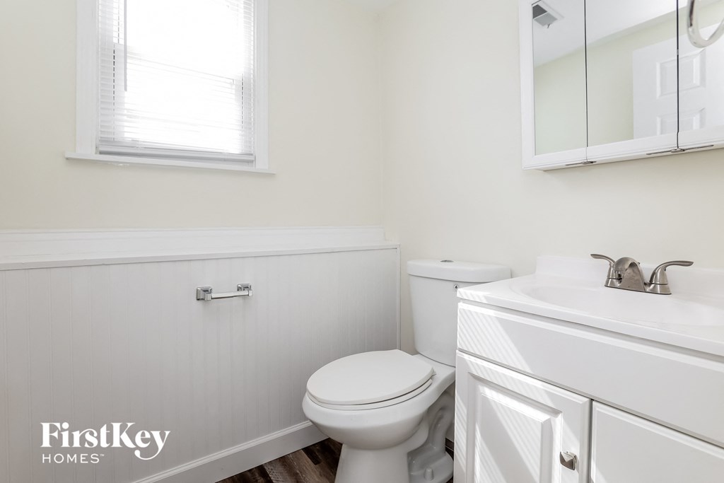a white bathroom with a toilet and a sink