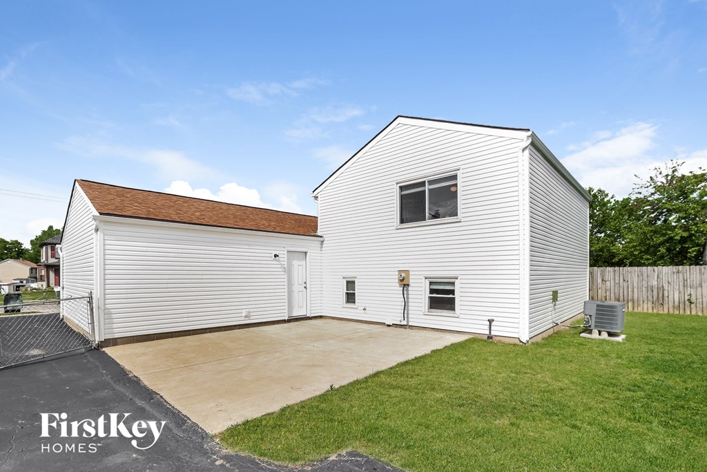 a small white house with a driveway and a garage