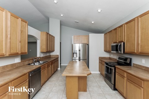 A kitchen with wooden cabinets and a center island.