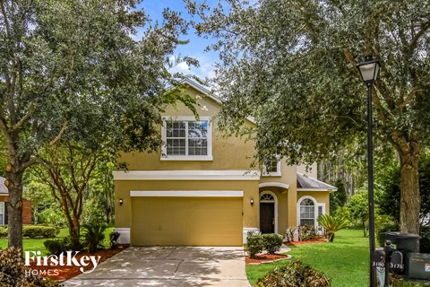 a yellow house with a yellow garage door and trees