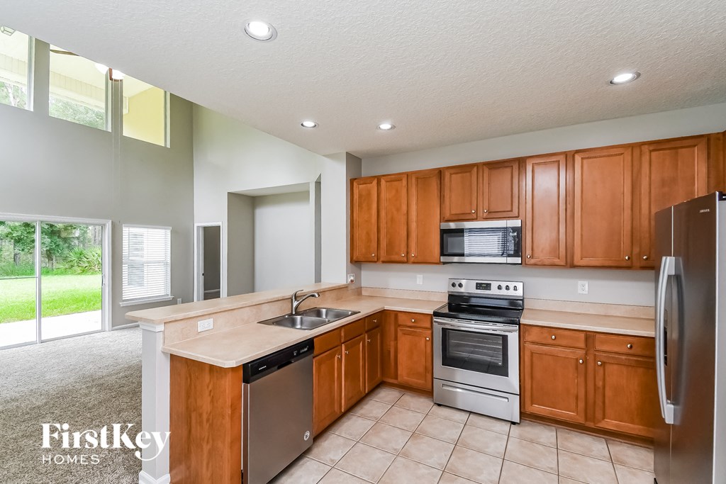 a kitchen with wooden cabinets and stainless steel appliances