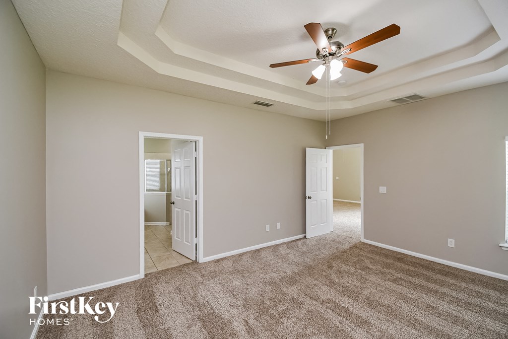 a living room with carpet and a ceiling fan
