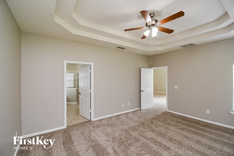 a living room with carpet and a ceiling fan