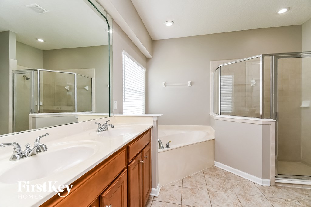 a bathroom with two sinks and a shower and a tub