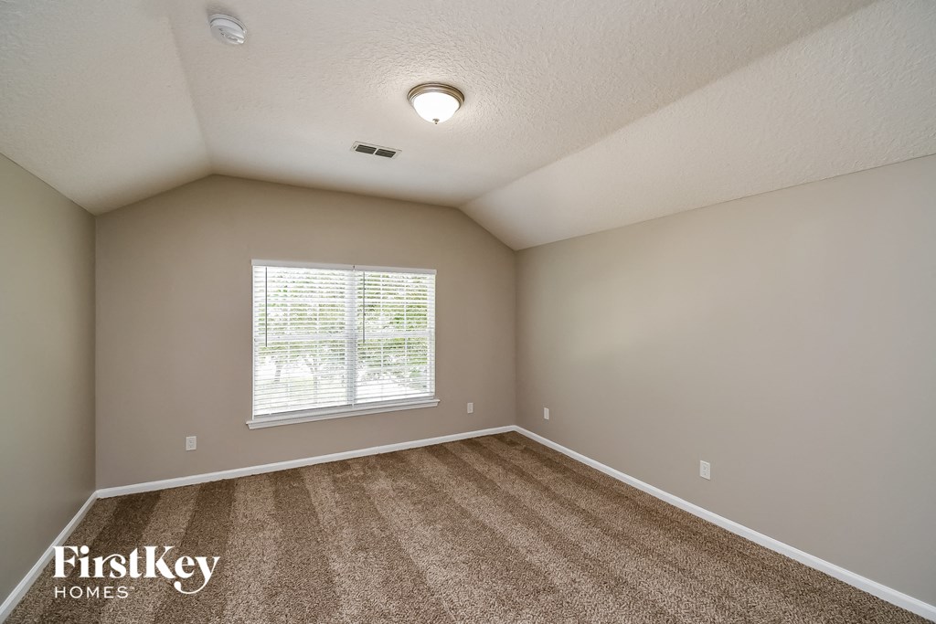 an empty room with carpet and a window