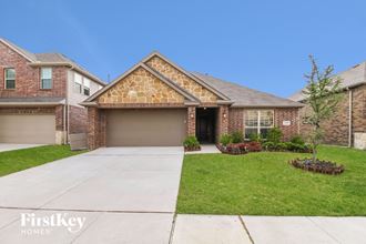 a brick house with a garage and a lawn