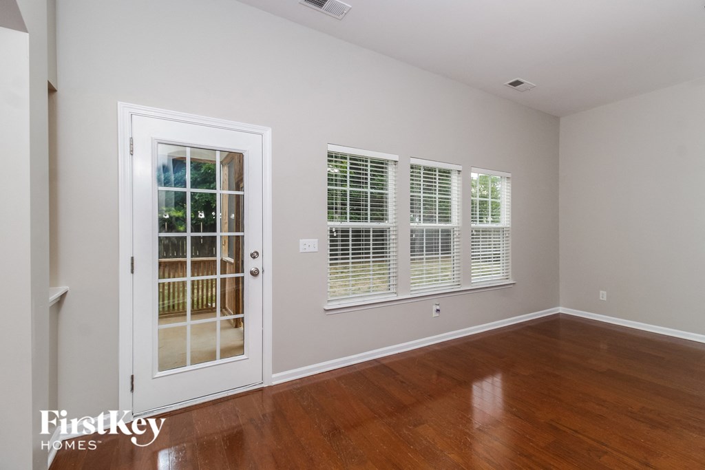 A room with a wooden floor and a sliding glass door.