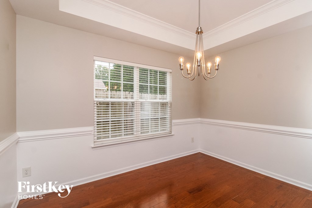 A room with wooden floors and a chandelier.