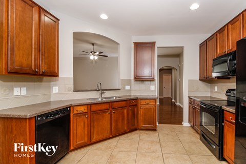 A kitchen with wooden cabinets and black appliances.