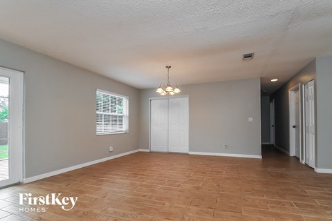 an empty living room with wood floors and a white door