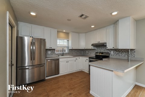 a white kitchen with stainless steel appliances and white cabinets