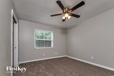 a bedroom with a ceiling fan and a window