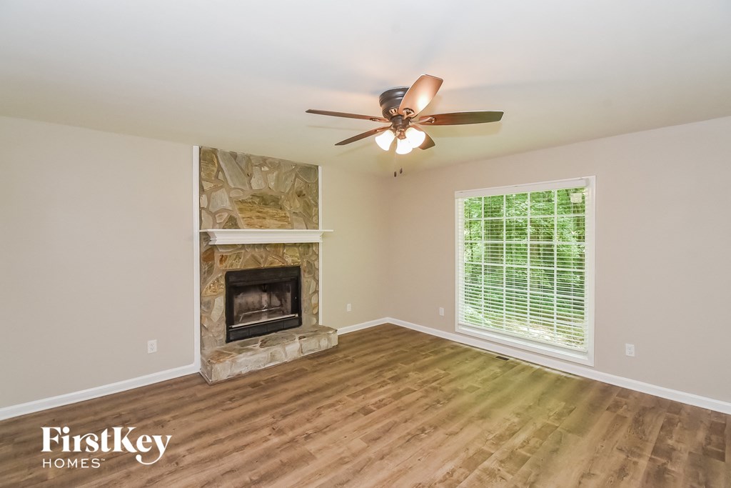 A room with a fireplace and a ceiling fan.