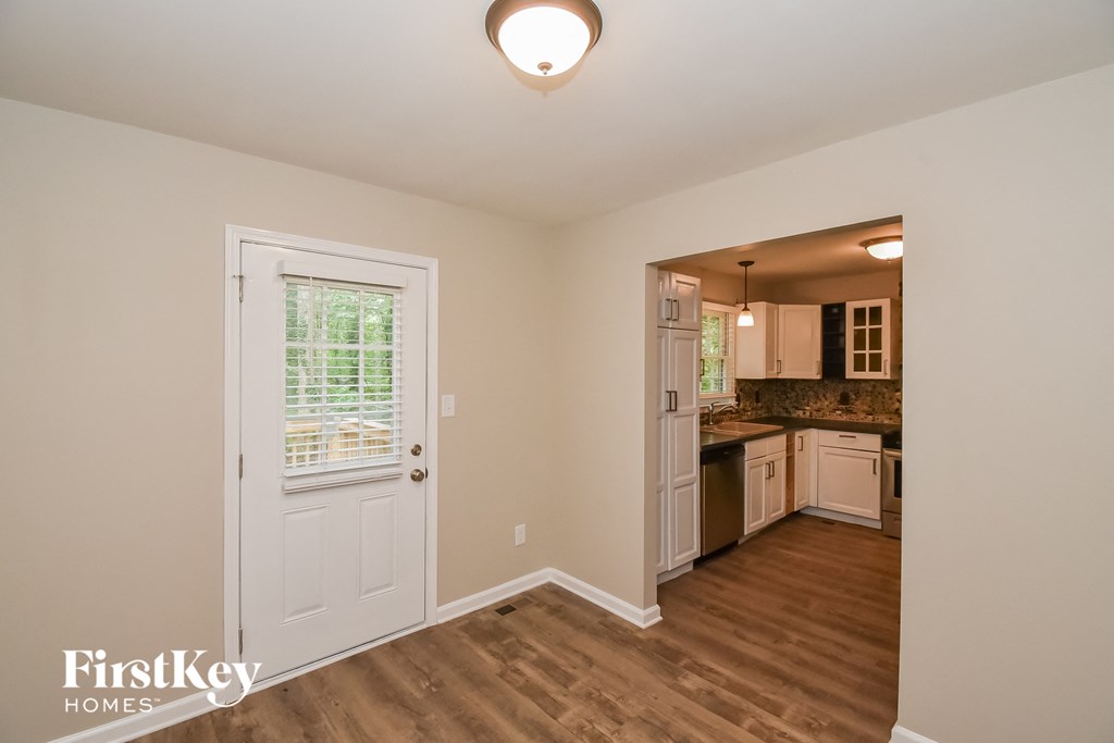 A room with a door and a window with blinds.