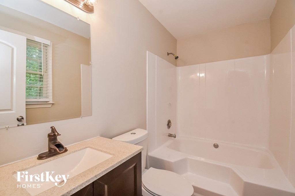 A bathroom with a white tub and sink.
