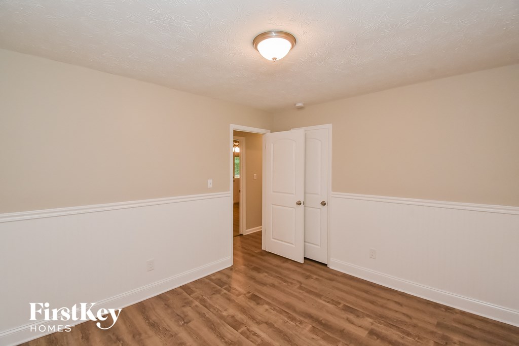 A room with a white door and a light on the ceiling.