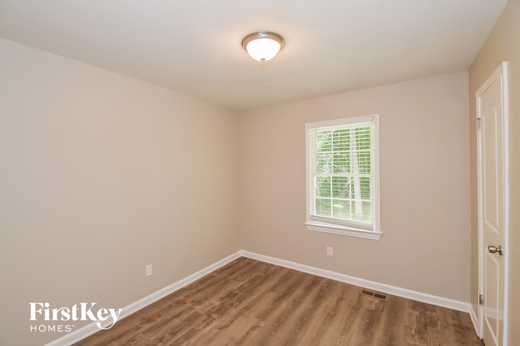 A room with a window and wooden flooring.