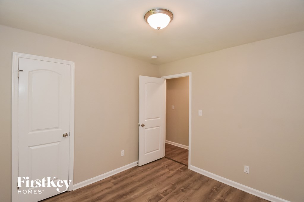 A room with a white door and a light on the ceiling.