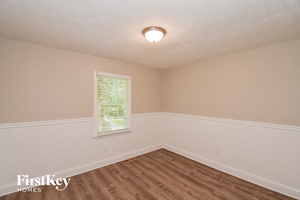 A room with a window and wooden flooring.