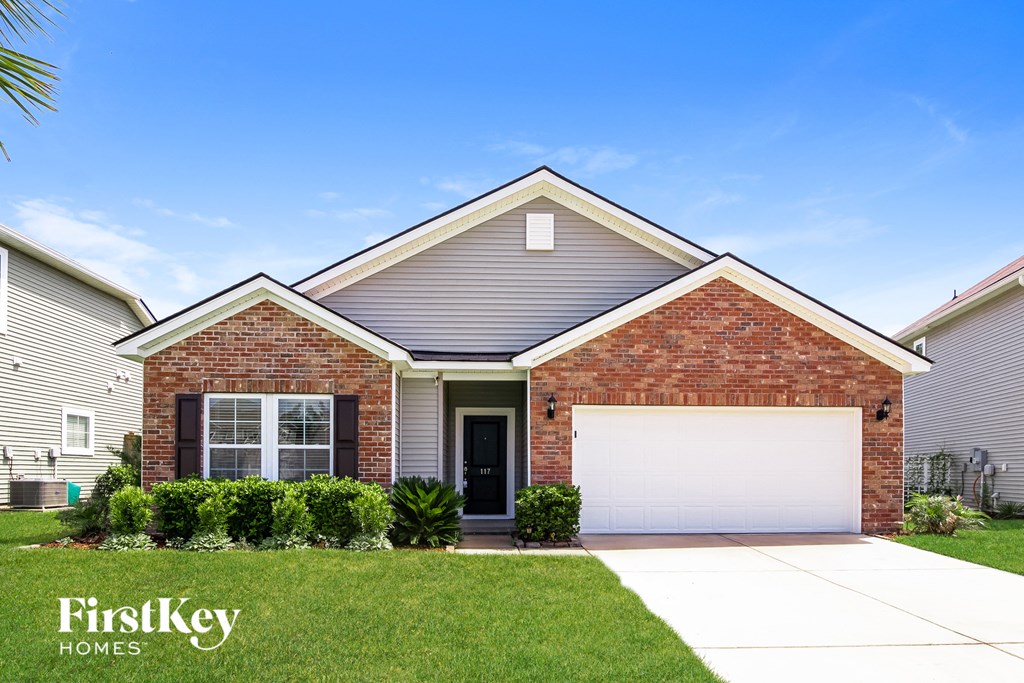 a house with a white garage door in front of a lawn