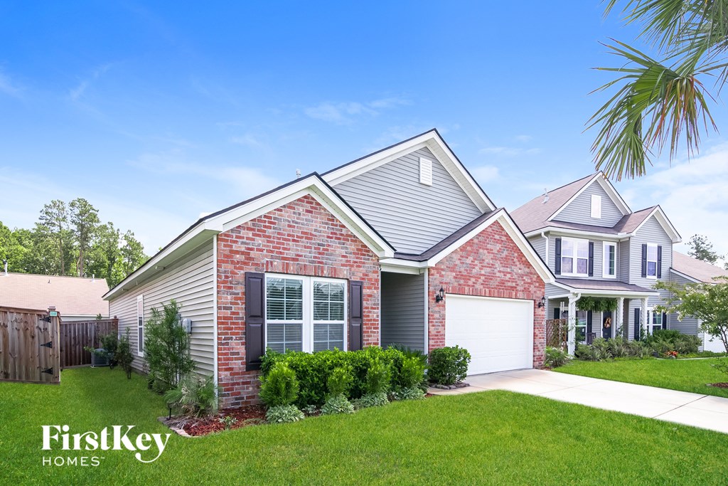 a brick house with a white garage door and a lawn