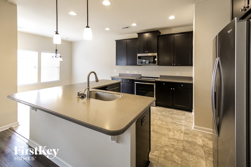 a large kitchen with black cabinets and stainless steel appliances