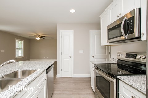 a kitchen with white cabinets and black appliances and a sink