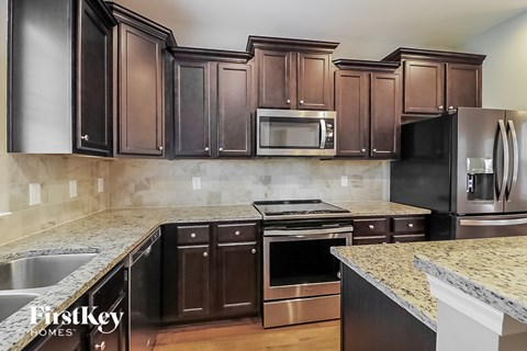 A kitchen with dark brown cabinets and stainless steel appliances.