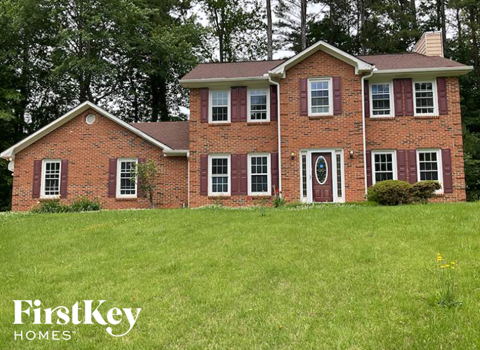 A brick house with a white door and windows.