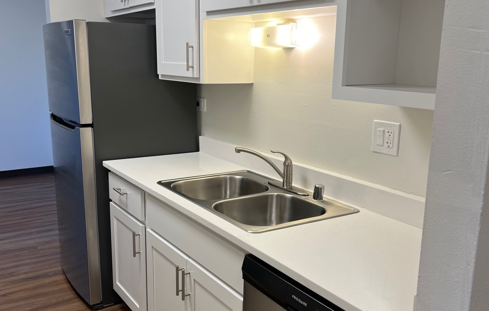 an empty kitchen with a sink and a refrigerator
