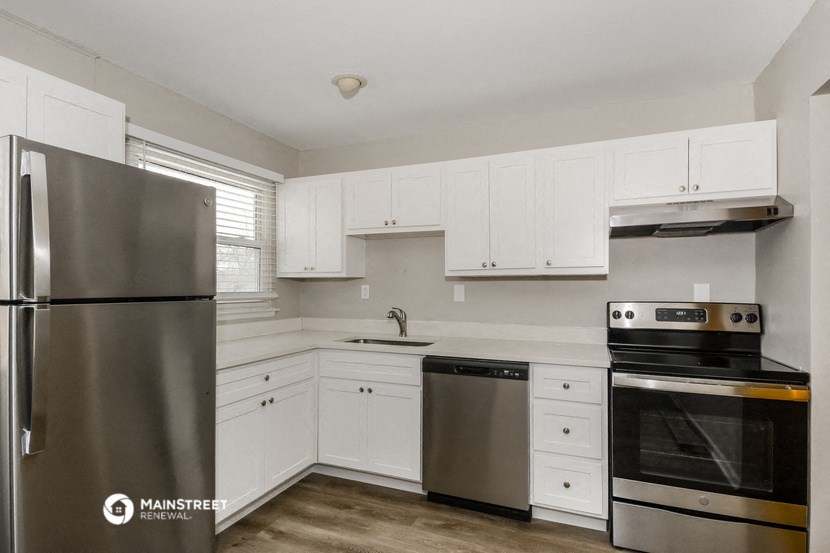 a white kitchen with stainless steel appliances and white cabinets